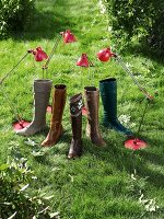 Five different boots and red lamps in lawn