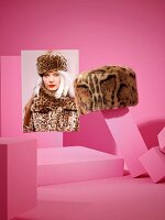 Animal printed fur hat and photo on pink background