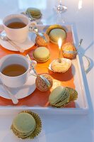 Christmas cookies, macrons tea cups and candle lights on tray