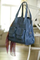 Blue leather bag with scarf, hanging