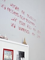 Spruch in roter Schrift auf weißer Wand, Wandsticker