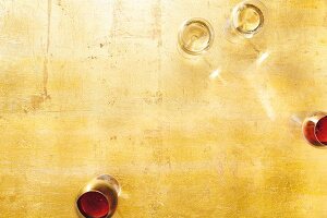 White wine glasses and red wine glasses on golden background, overhead view