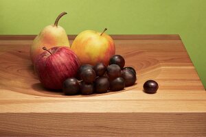 Apple, peach, pear and grapes on wooden board