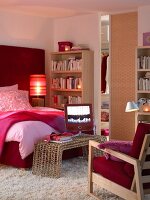 Schlafzimmer mit Bücherregal, Sessel und Fernseher