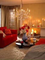 Living room with red sofa, fur carpet, lit candles and chandelier