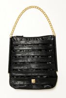 Black bag with golden link chain handle on white background