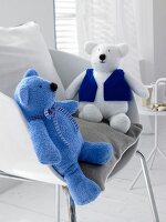 Two blue and white teddy bears on chair