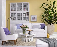 Wohnzimmer, Helle Polstermöbel, Vitrinenschrank und Grünpflanzen