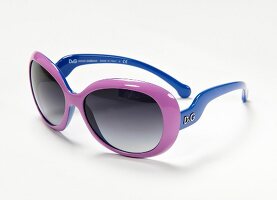 Close-up of pink and blue sunglasses on white background