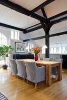 Rustic oak table and chairs with illuminated lamps in dining room