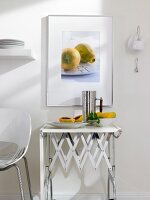 Photography with fruit motif in silver frame against white wall