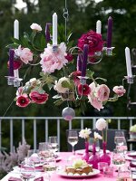 Chandelier made of flowers and candles above laid out table