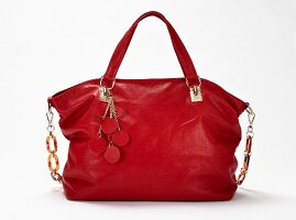 Bright red leather bag on white background