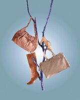 Beige bags and shoes hanging on blue branches