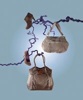 Grey bags and shoes hanging on blue branches