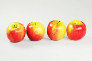 Close-up of four apples on white background