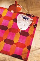 Colourful carpet in 60s style with table lamp, overhead view