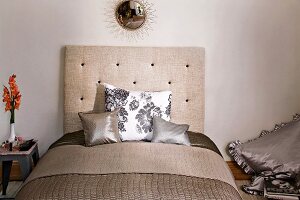 Elegant modern bed with beige headboard and cushions