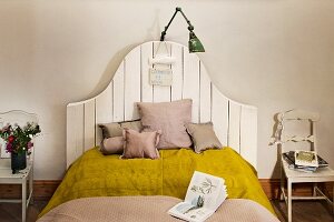 Modern bed with country style headboard, cushions and lamp
