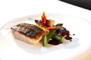 Close-up of sea bass, octopus and chorizo terrine with mandarin peel puree on plate