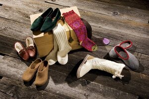 Various colourful socks and shoes on wooden surface