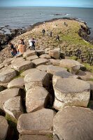 Tourists relaxing on Giant's Causeway at Antrim coast, Ireland