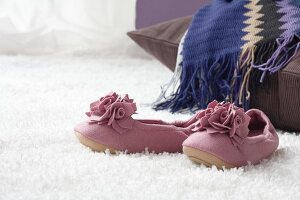 Pink slippers on white carpet