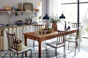 langer Holztisch und filigrane Eisenstühle in Küche
