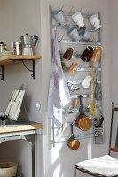 Hooks shelf with metal cups, mugs and kitchen utensils