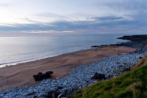 View of Fanore beach and horizon over sea at dusk, Ireland, UK