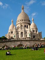 People relaxing in front of Sacre Coeur with blue sky, Paris, France