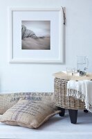 Coffee bags and cushion made of jute with rattan stool against white wall