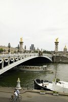 Ferries passing under Alexander III bridge in Paris, France