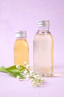 Glass bottles with generic ethereal oils used for aromatherapy on pink background