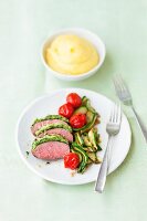 Lamb with a herb crust, courgette and tomatoes