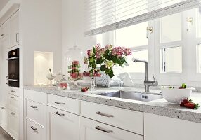Flowers and sink on white kitchen working area
