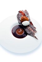 Cassis jelly with ganache, madeleine, chocolate caramel and vanilla ice cream on plate