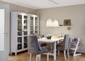Dining table with crockery cabinets and illuminated hanging lamps