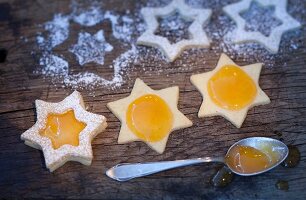Star-shaped biscuits being spread with jam