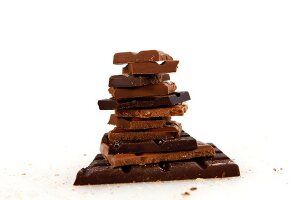 Various chocolate bars stacked on white background