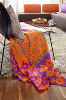 Orange patterned blanket and cushion on chair