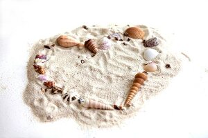Heart made of sea shells on sand