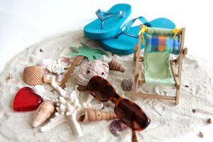 Sunglasses with deck chair, heart, sea shells and palm tree on sand