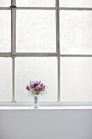 Vase with flowers on window sill