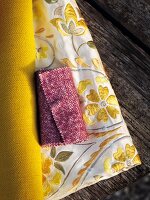 Close-up of three different types of fabrics on wooden bench