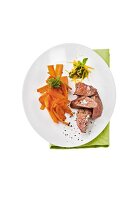Lamb with carrots and mint topping on plate