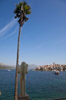 Rear view of statue with palm tree on Korcula port, Dubrovnik-Neretva, Croatia