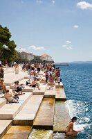 Tourists enjoying at Sea Organ on the promenade in Zadar, Croatia