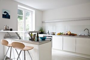 Küche mit weißen Unterschränken, Tresen, Sitzhocker