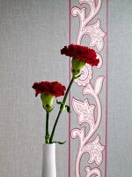 Close-up of flower vase against floral patterned wallpaper